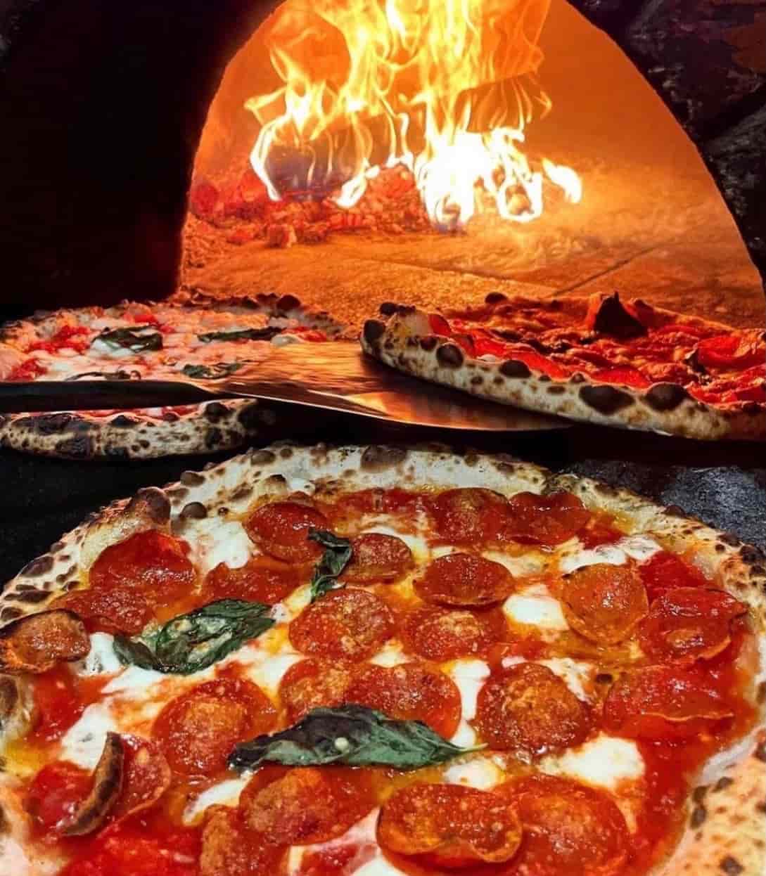 Wood-fired pizza with blistered crust, mozzarella and fresh basil