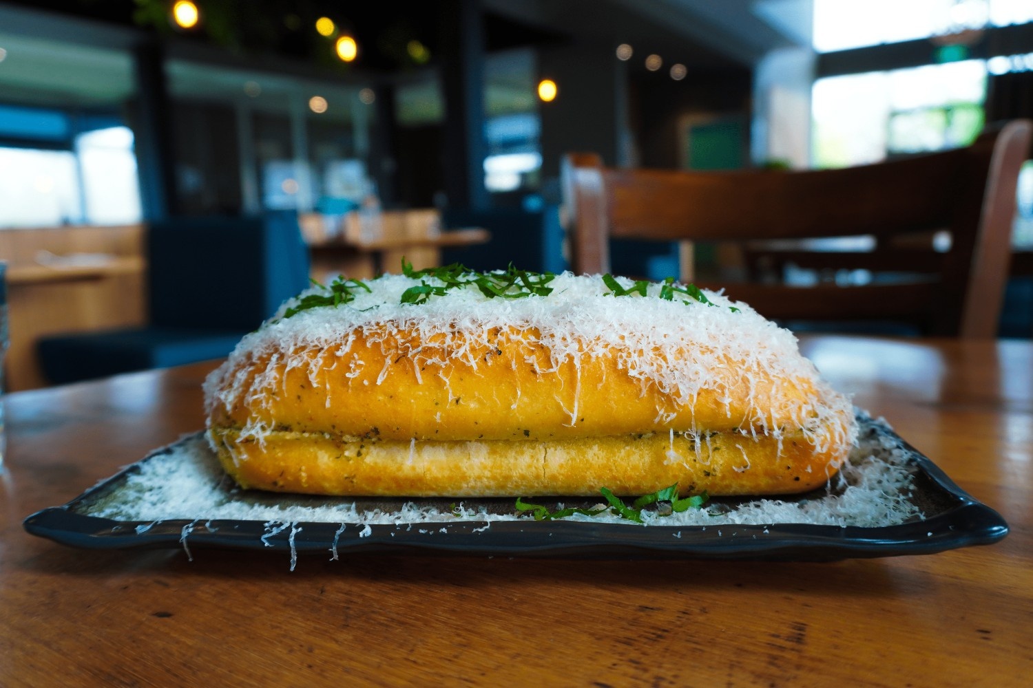 Warm house garlic bread loaf with shaved parmesan and herbs