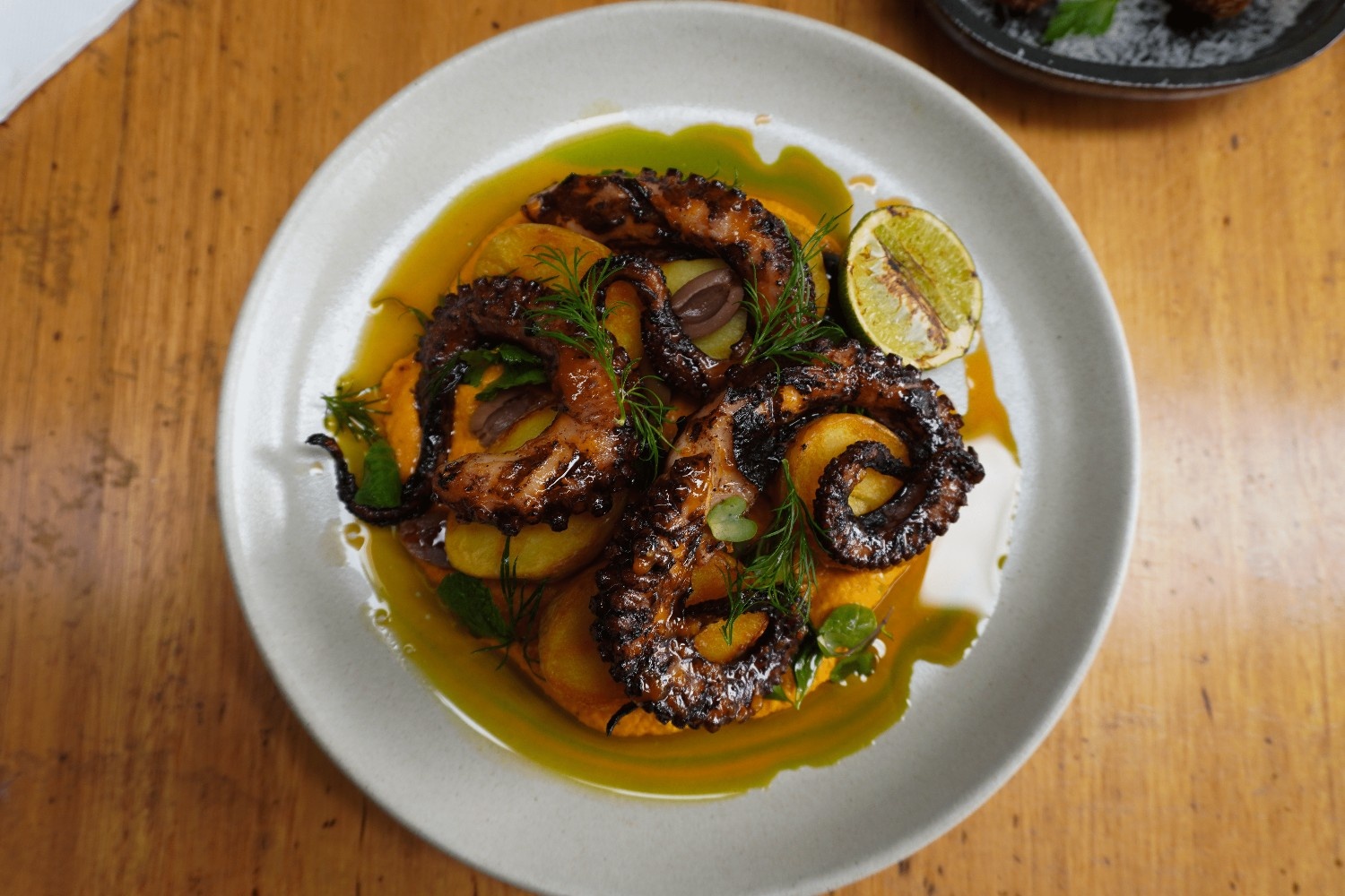 Charred octopus with roast potatoes, citrus and herb oil