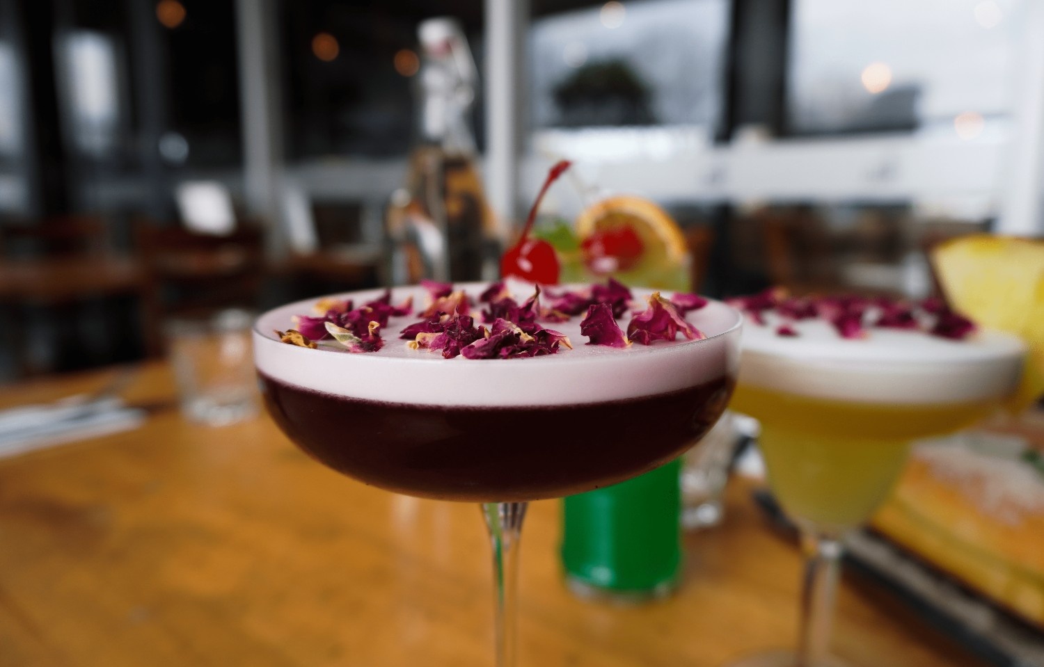 Signature berry sour cocktail with rose petals