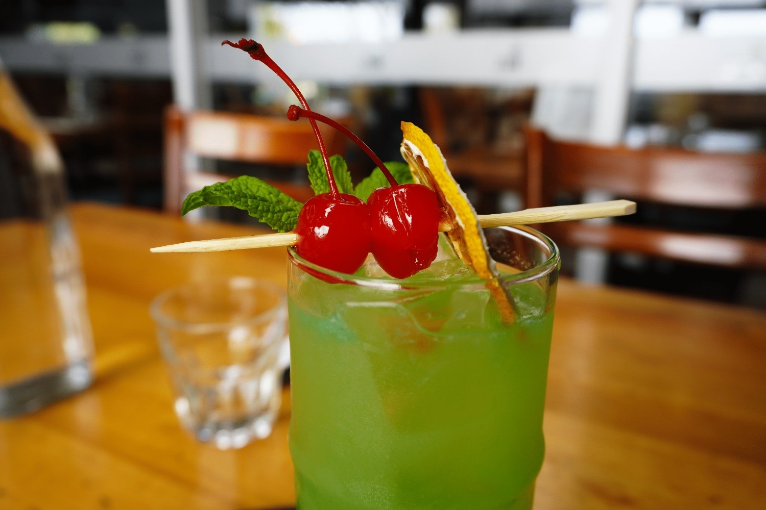 Lime and mint mocktail garnished with cherries and dried citrus